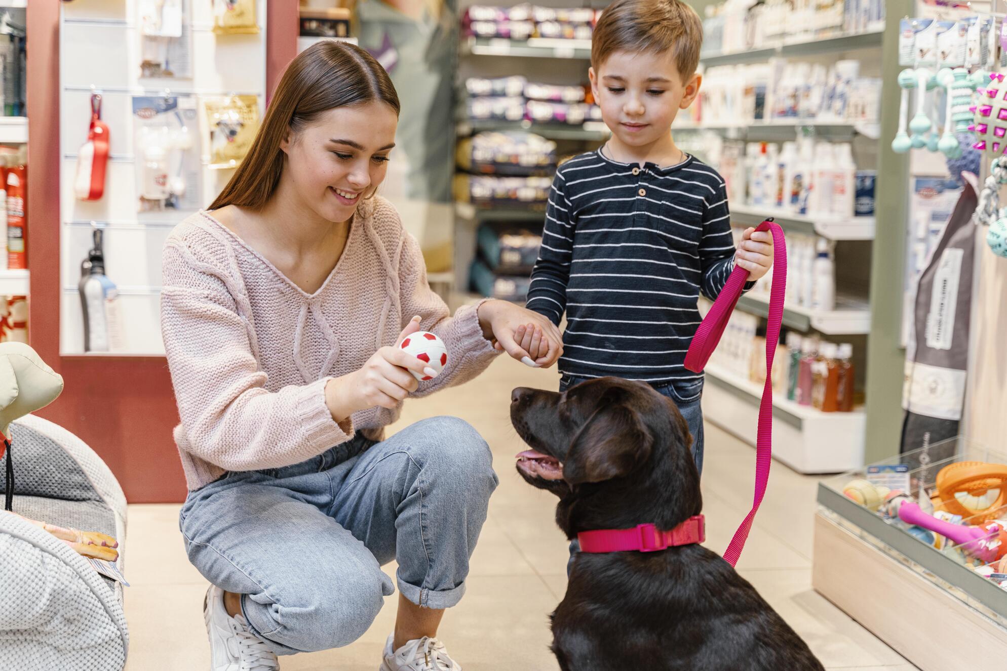 nino y madre en la tienda de mascotas con su perro